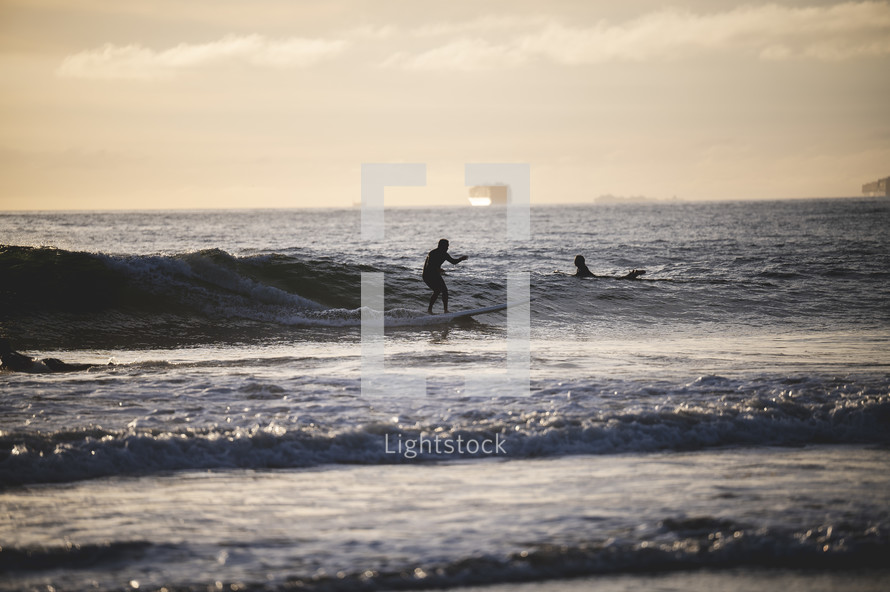 surfers catching waves in Newport Beach, CA