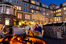 Couple sitting by a fire pit.