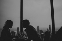 A couple at a restaurant overlooking a city.