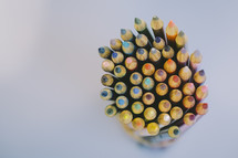 Tips of colored pencils in a pencil holder.