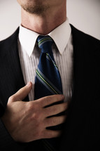 a man fixing his tie 