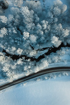 Aerial view of frozen river running by a road