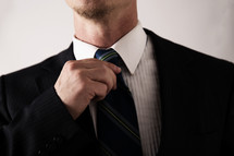 a man straightening his tie 