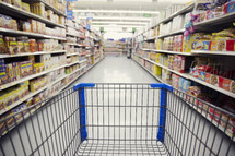 pushing a shopping cart through a grocery store