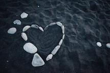 heart shaped stones in black sand 