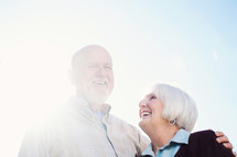 a mature couple standing together and laughing.