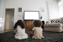 kids watching television in a living room.