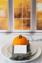 Thanksgiving place setting with a blank card in front of a kitchen window
