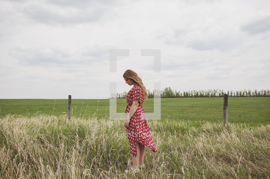 woman standing alone in a field 
