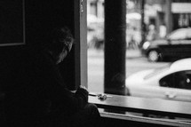Man praying in the window of a coffee shop.