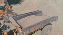 Aerial shot of a large loader loading a truck in a construction site.