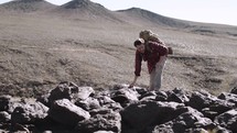 a man hiking up a desert mountain 