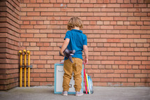 a child standing in front of locker reading a book 