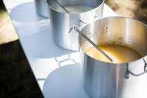 stock pots of soup on tables at a soup kitchen 