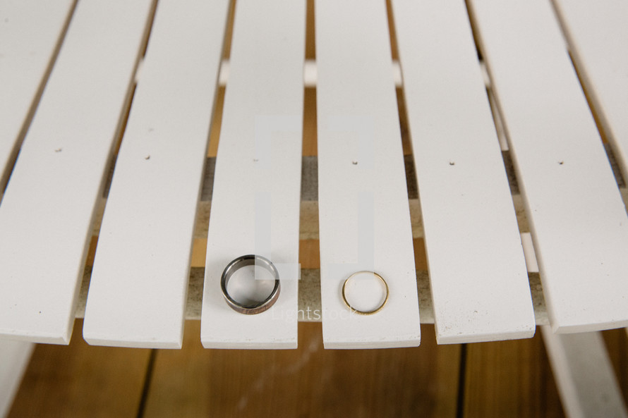 wedding bands on a white folding chair 