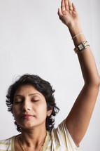 a woman with her hand raised in praise 