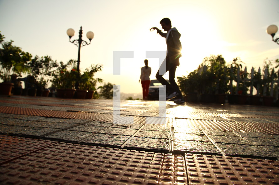 man skipping on a brick paver courtyard 