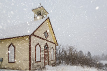 snow falling around a winter church 
