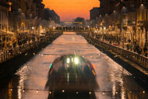 Illuminated street and boat in the canal