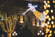 Christmas angel decoration and illuminated trees in the street