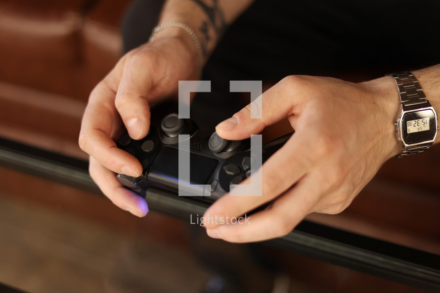 Playing games concept. Part body man with joystick play game on console. Male hands holding pad. High quality photo.