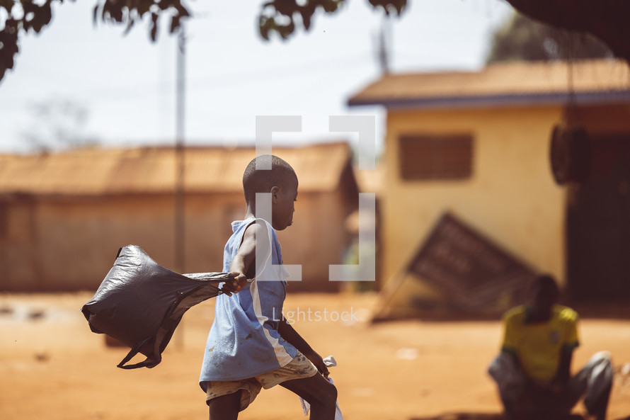 African child plying with a garbage bag in a small village in the Ivory Coast in west Africa