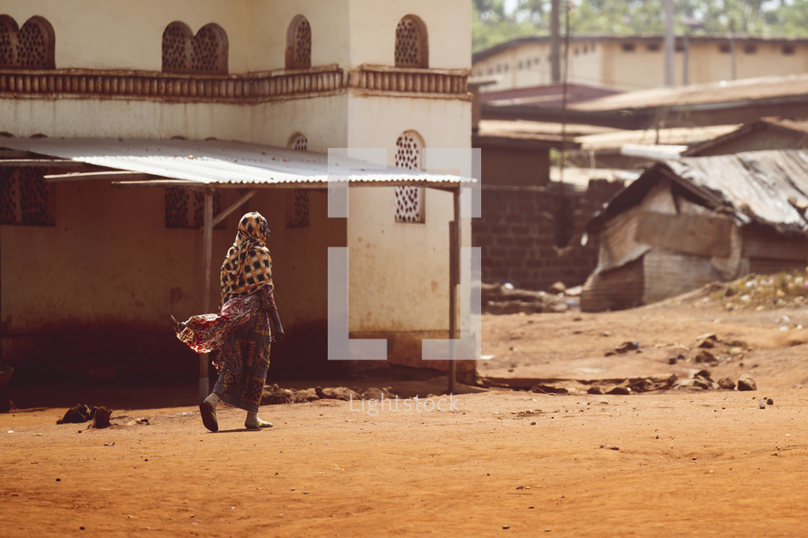 Muslim African woman walking in a dusty village in the Ivory Coast, West Africa