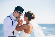 bride and groom standing on a beach 