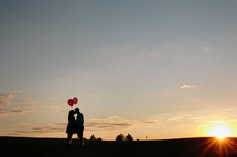 man and woman in an embrace holding balloons
