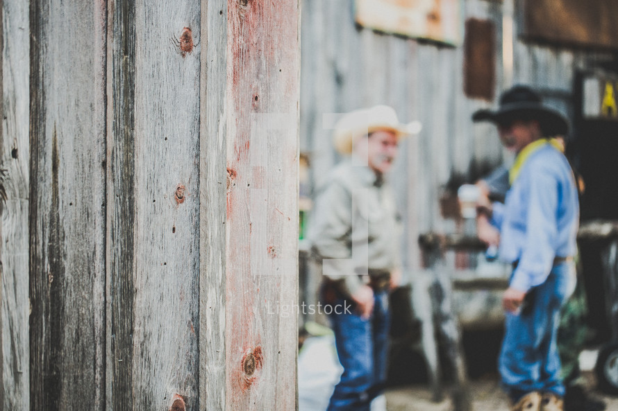 two men standing wearing cowboy hats