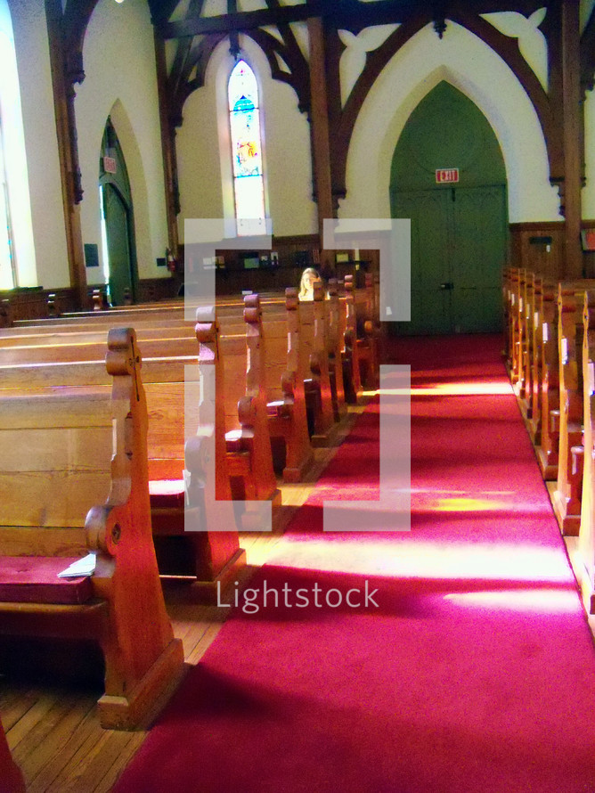red carpet on the aisle in a church with pews 