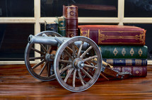 cannon decoration and books on a table 
