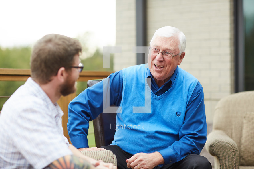 elderly man talking to a young man 
