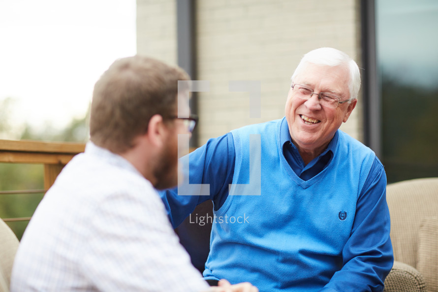 elderly man talking to a young man 