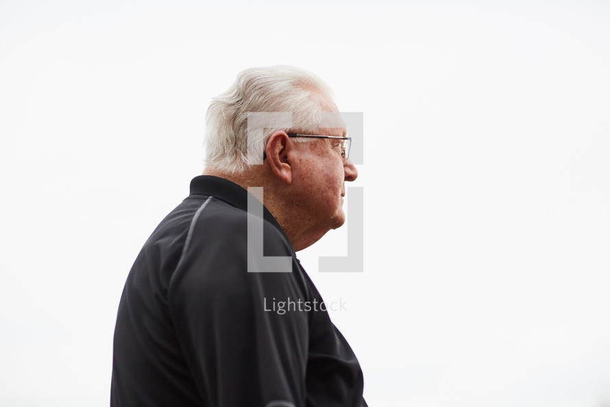 elderly man standing against a white background 