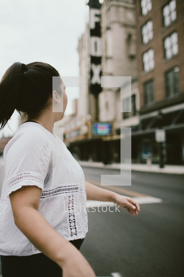 a woman crossing a street downtown 