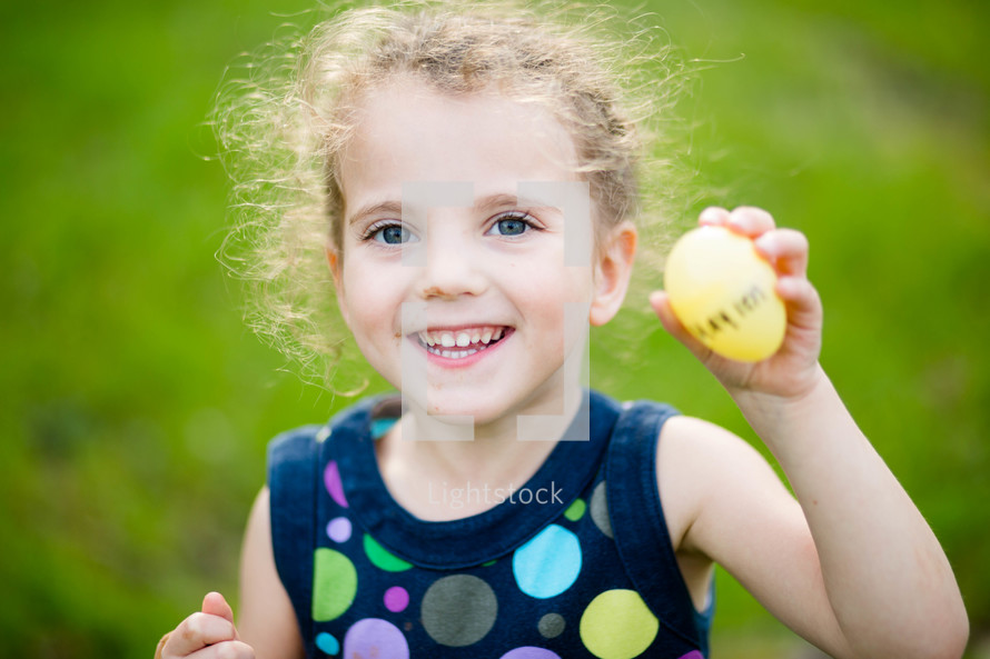 a little girl holding an Easter egg 