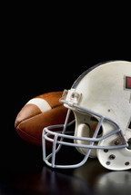 football and football helmet on a black background 