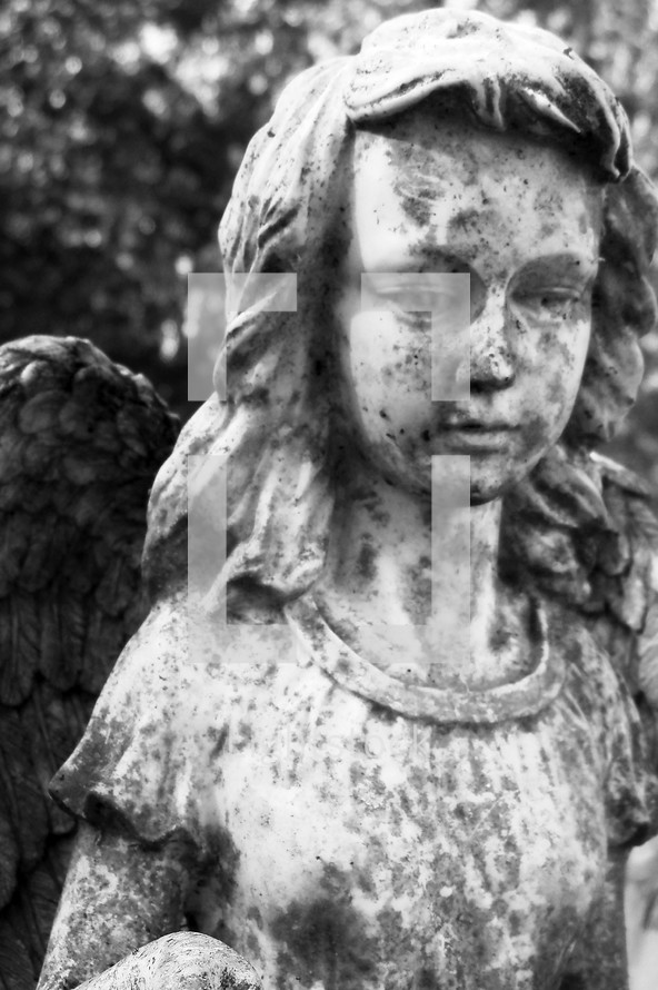 A statue of a female angel weathered by time, weather and life looking over a grave site as a reminder that Angels watch over us in this life and will be our companions in the Heavenly Kingdom of Christ. 