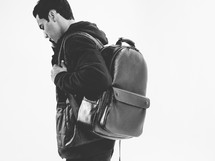 young man with a leather backpack 