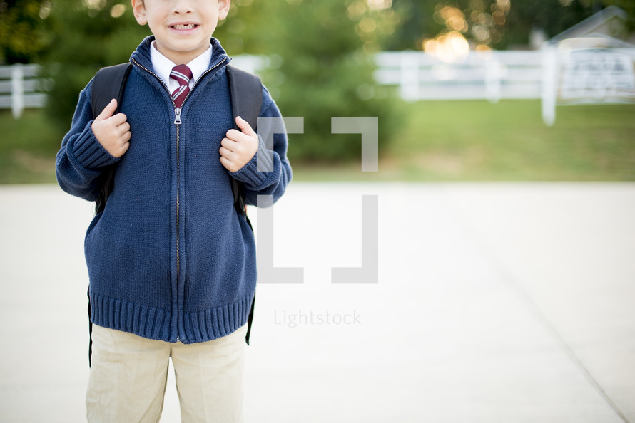 kid missing a tooth with a book bag 