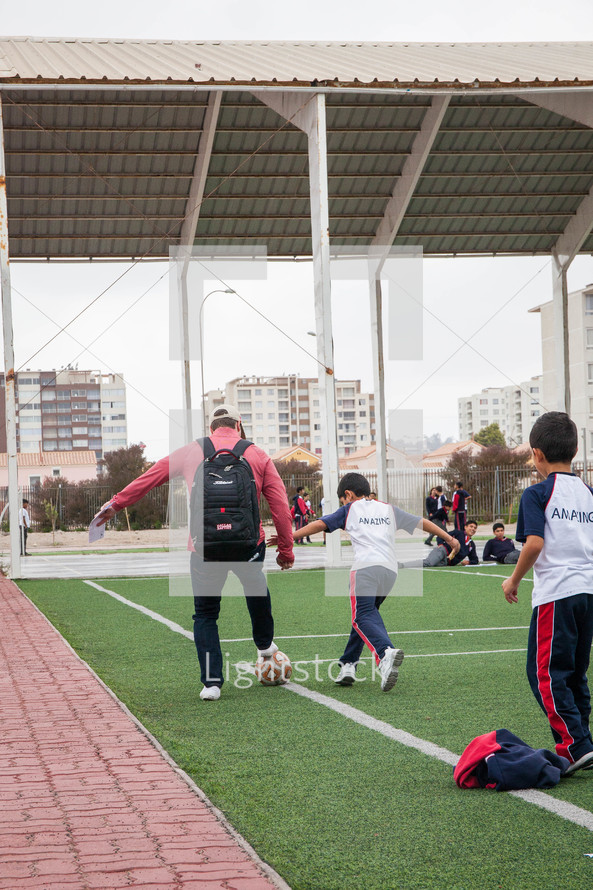 kids on a soccer field with their coach in La Serena, Chile