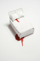 blood on the sheets and floor of a white bed 