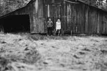 man and woman standing in front of a barn