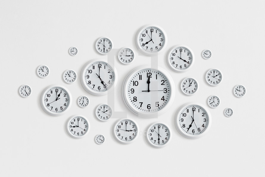 Round white clocks on a white wall. 