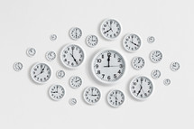 Round white clocks on a white wall. 
