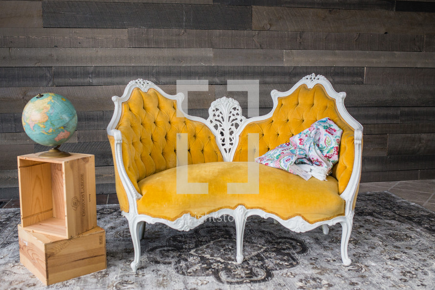 yellow vintage couch and globe on wood crates 