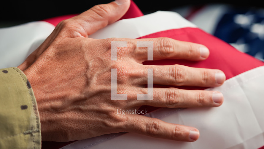 Hand of a solider touching USA flag