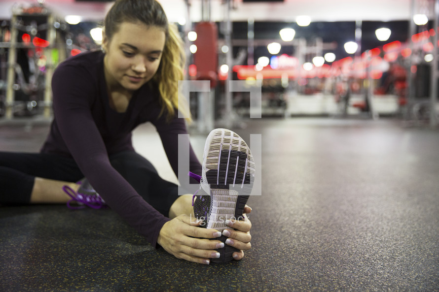 a woman stretching in the gym