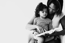 mother and toddler daughter reading a Bible together 